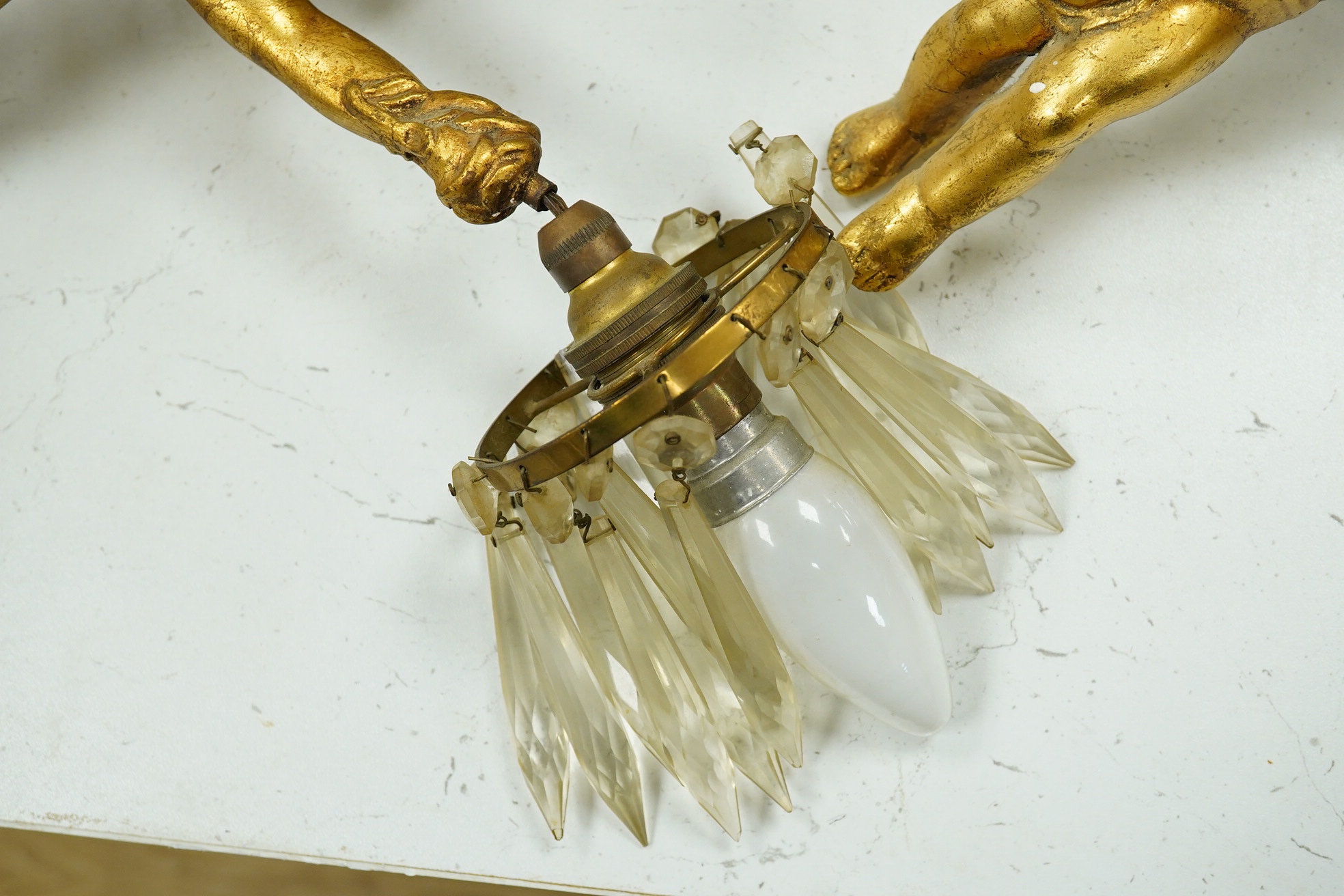 A pair of gilt plaster hanging ‘cherub’ lustre drop light fittings, 24cm long. Condition - fair to good